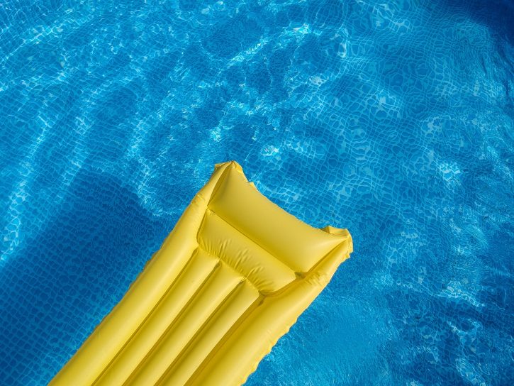 Top view of an inflatable mattress in a backyard swimming pool